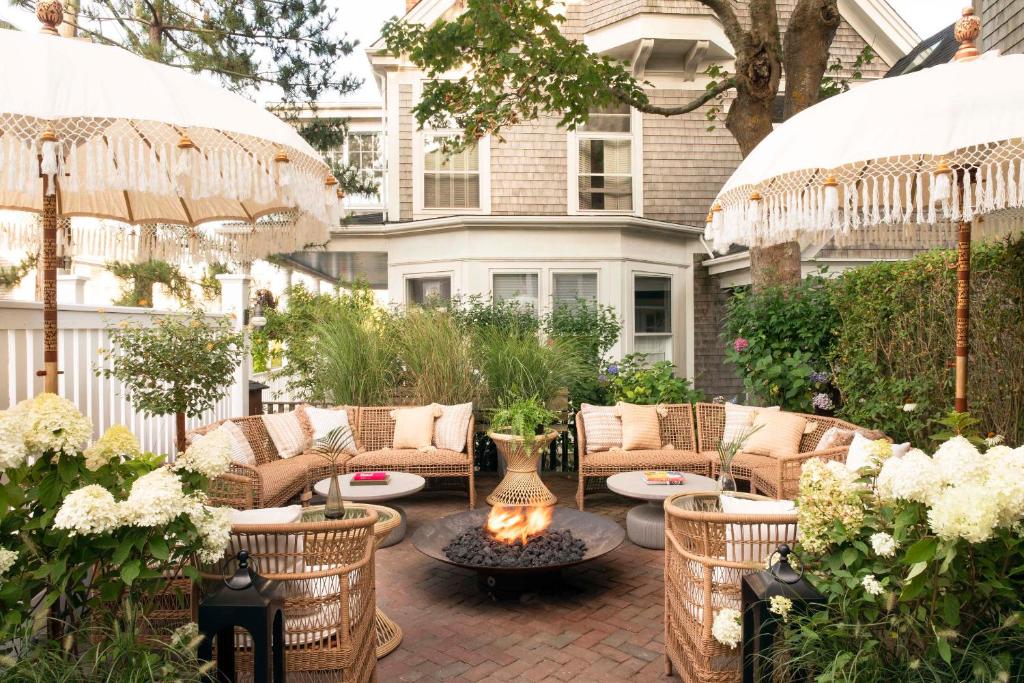 un patio con sillas, mesas y sombrillas en Life House, Nantucket en Nantucket