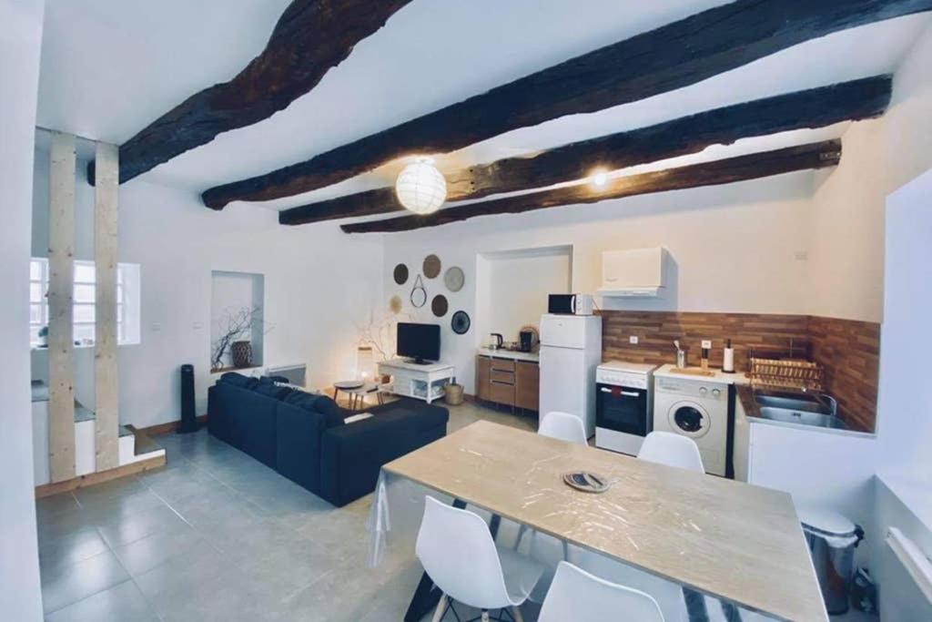 uma cozinha e sala de estar com mesa e cadeiras em Le Cosy B em La Gouesnière