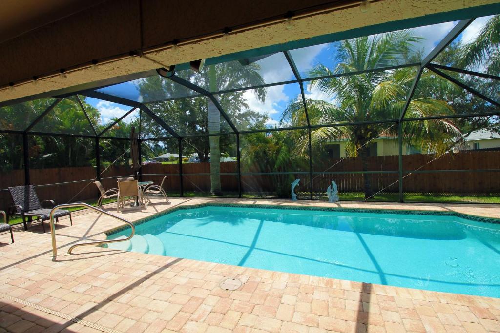 - une piscine dans un bâtiment doté d'une grande fenêtre dans l'établissement Heated saltwater pool, newly furnished, close to shopping and more - Villa Tropical Paradise, à Cape Coral