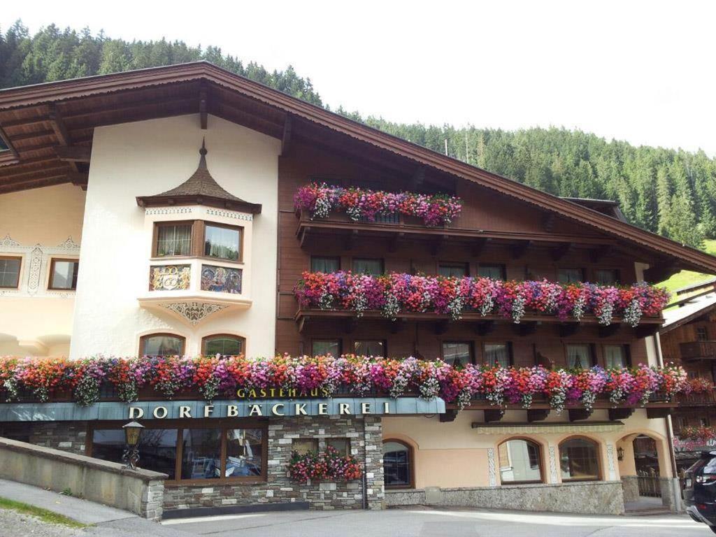 a building with flower boxes on the side of it at Gästehaus Dorfbäckerei in Tux