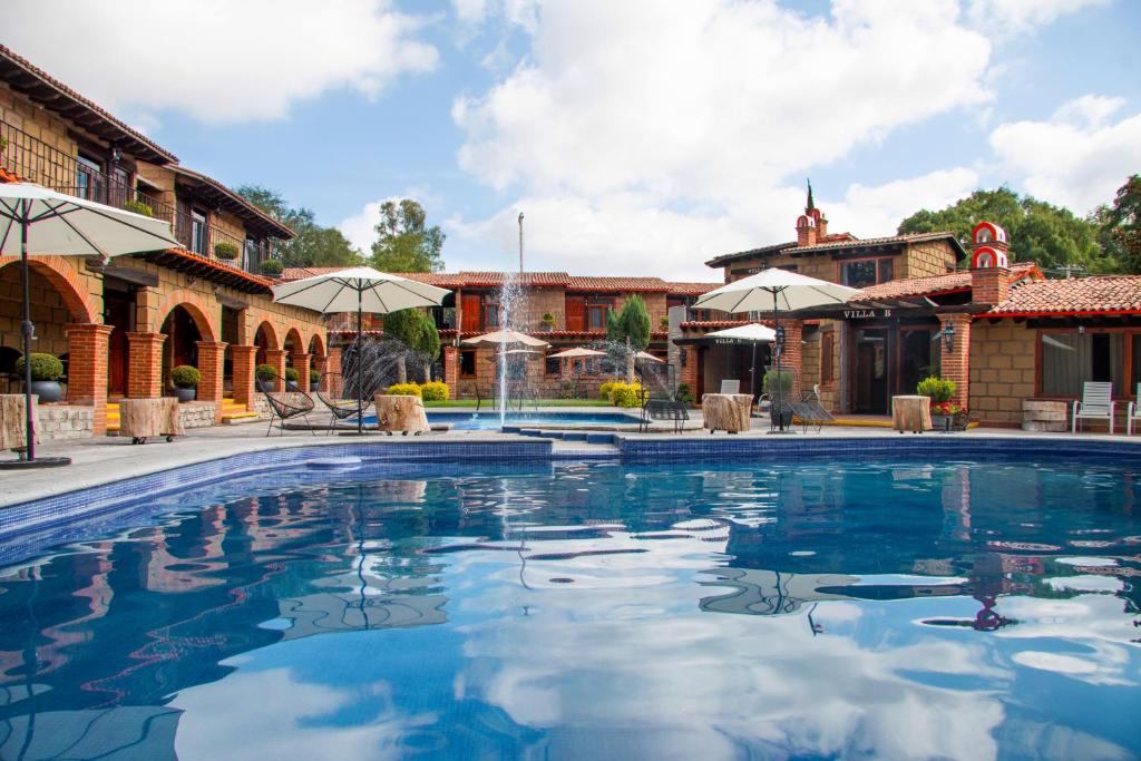 特基斯基亞潘的住宿－Hotel Sol y Fiesta，一个带椅子和遮阳伞的游泳池