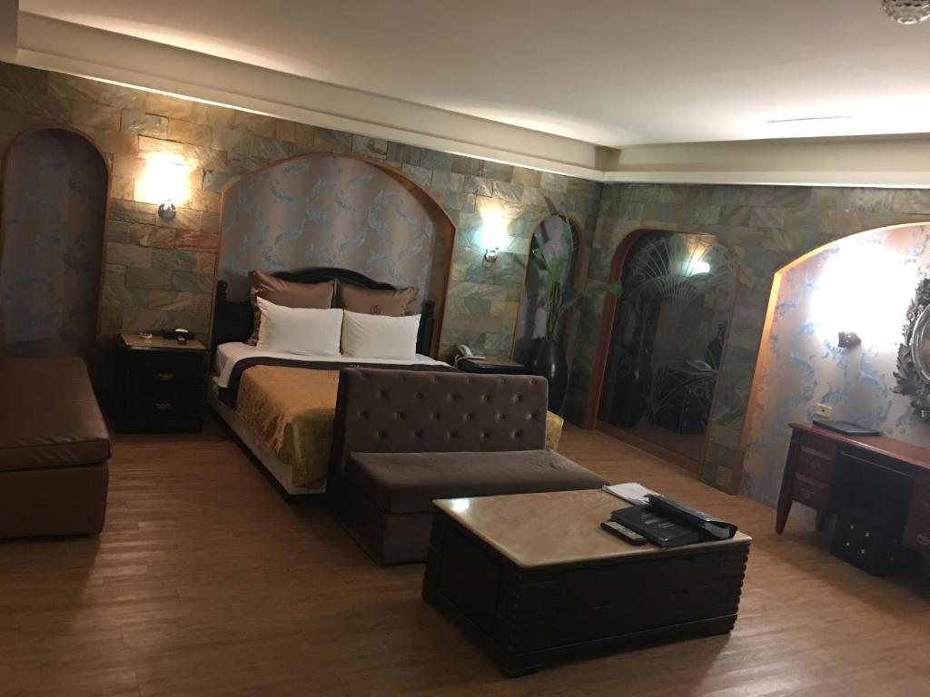 a hotel room with a bed and a couch at Discovery Motel - Tucheng in Tucheng