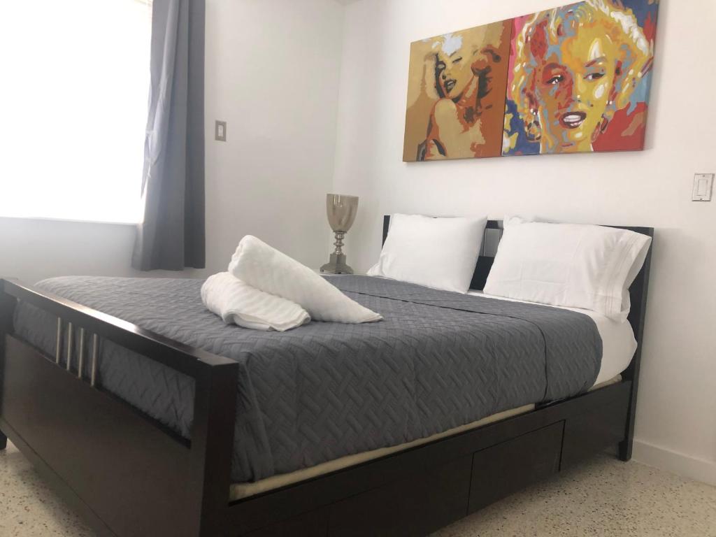 una camera da letto con un letto e un dipinto sul muro di Explore Wynwood 2bedrooms and free parking a Miami