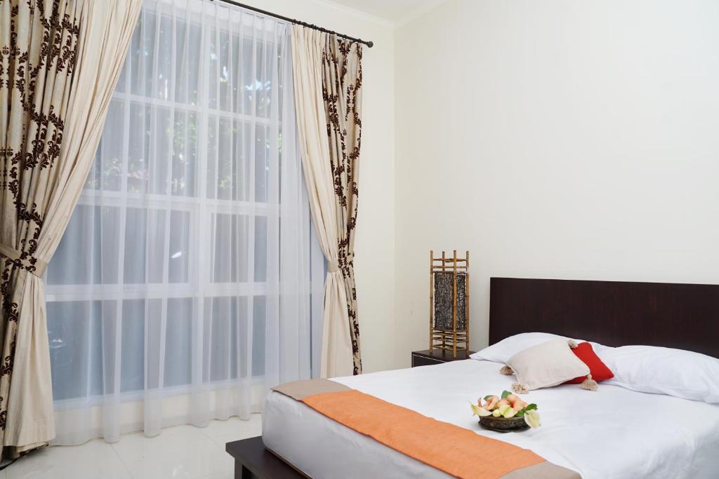 a bedroom with a bed and a large window at Villa Sanlias in Bogor