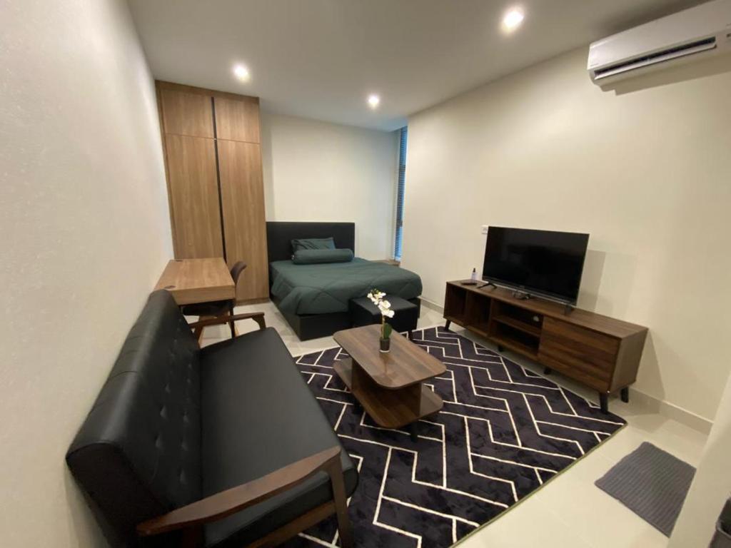 a living room with a couch and a television at Cozy Studio at Kozi Square in Kuching