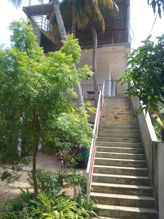 a staircase leading up to a building with trees at Mallika Resort in Mirissa