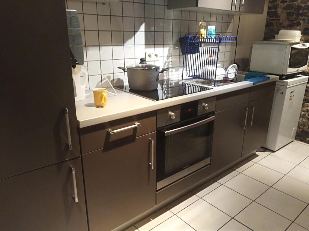 a kitchen with a sink and a stove top oven at Un studio à louer ds un endroit calme près de la ville de Dinant in Dinant
