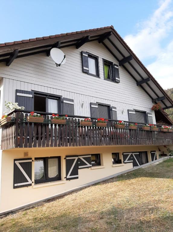 une maison avec un balcon fleuri dans l'établissement Le Mélusine, à Gérardmer
