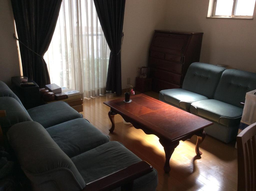 uma sala de estar com um sofá e uma mesa de centro em 民泊Ｒｉｋａ em Tokai