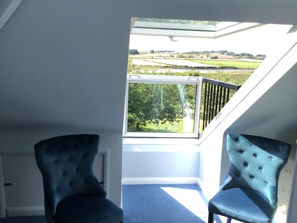 two chairs sitting in a staircase with a window at Westlea Guest House in Alnmouth