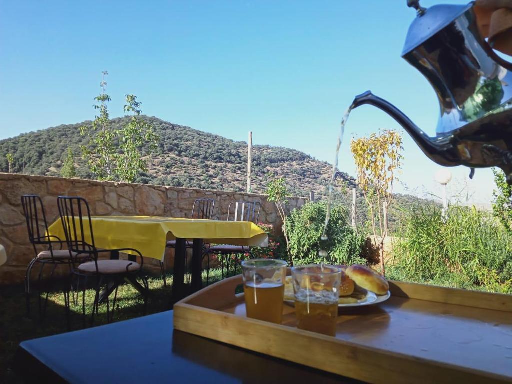 un tavolo con vassoio di cibo e bevande su un balcone di Le Gite du Barrage a Zaouia Ben Smine