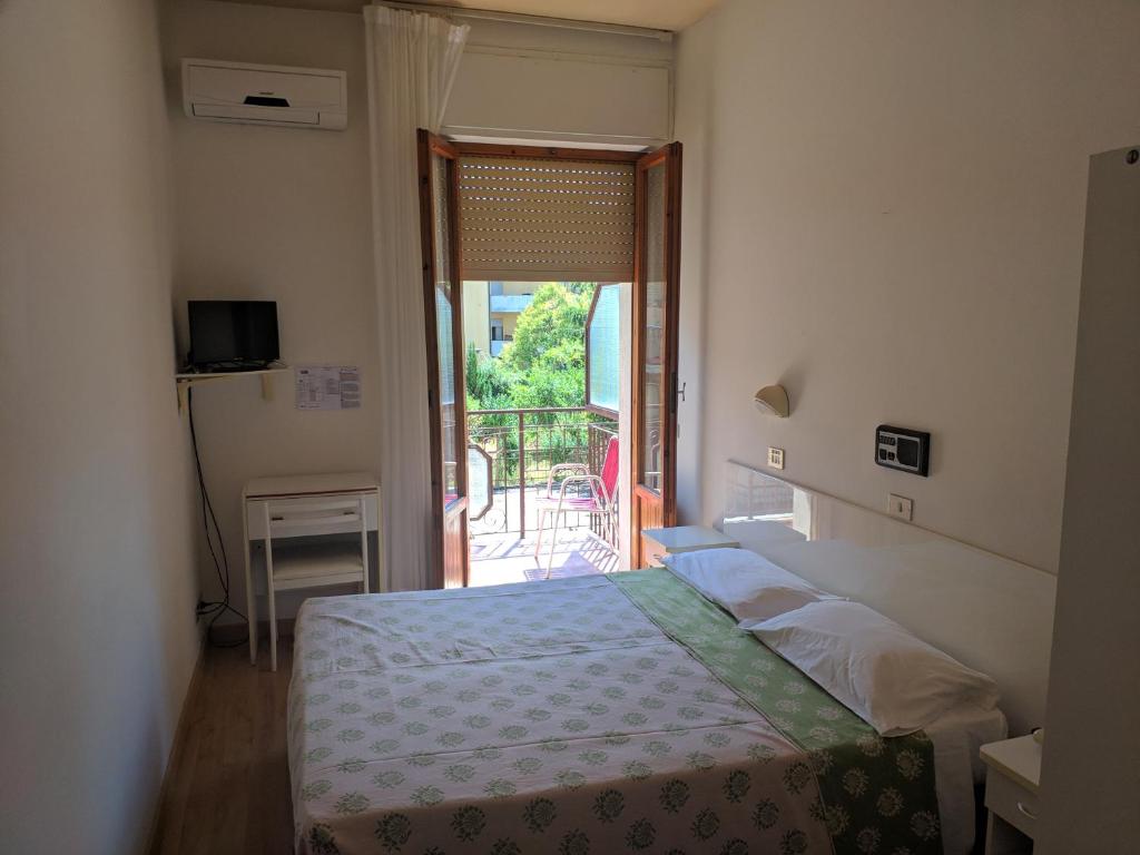 a bedroom with a bed and a door to a balcony at Hotel Luana in Chianciano Terme