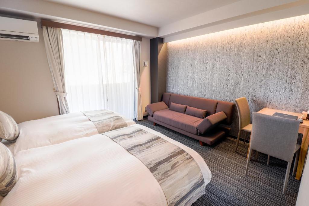 een hotelkamer met een groot bed en een bank bij Stay SAKURA Kyoto TSUBAKI in Kyoto