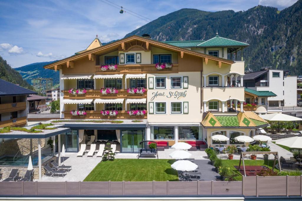 un gran edificio con sombrillas delante en Hotel St. Georg, en Mayrhofen