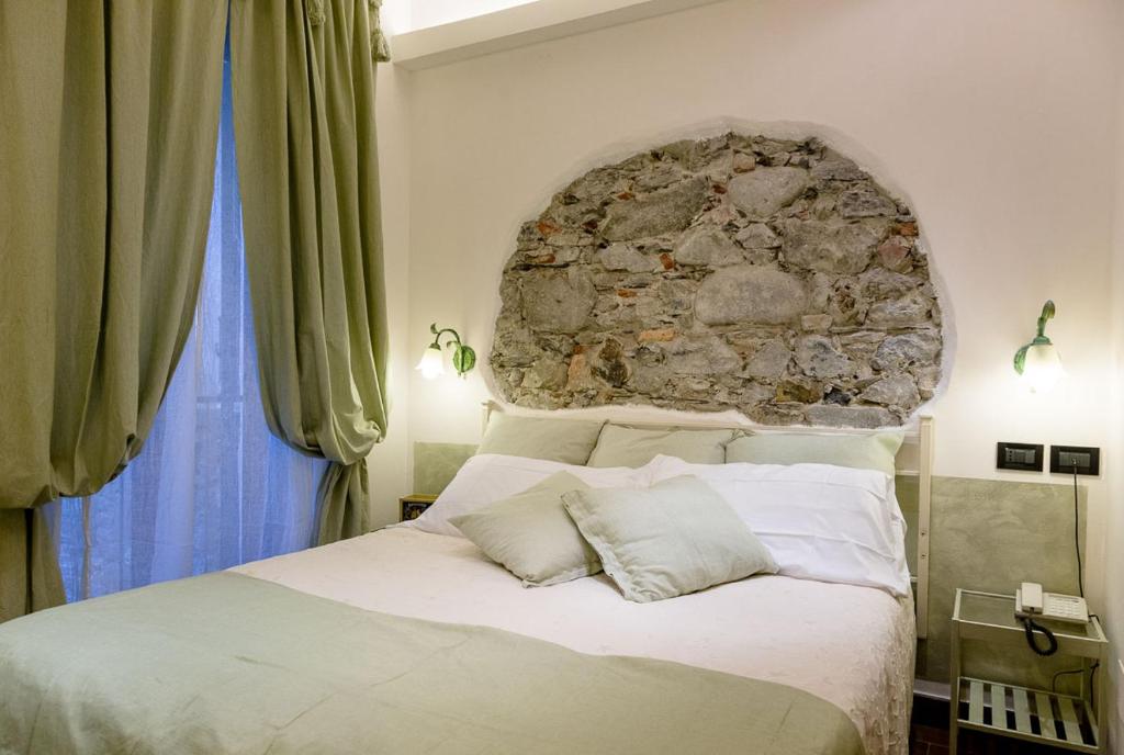 a bedroom with a large bed with a stone wall at Hotel Marina in Monterosso al Mare