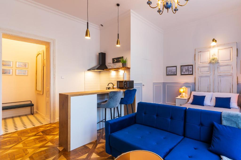 Il comprend un salon avec un canapé bleu et une cuisine. dans l'établissement Apartamenty Rejtana, à Przemyśl