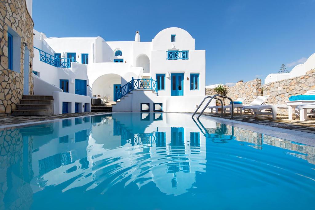 a swimming pool in front of a white building at Seaside by Manos in Kamari