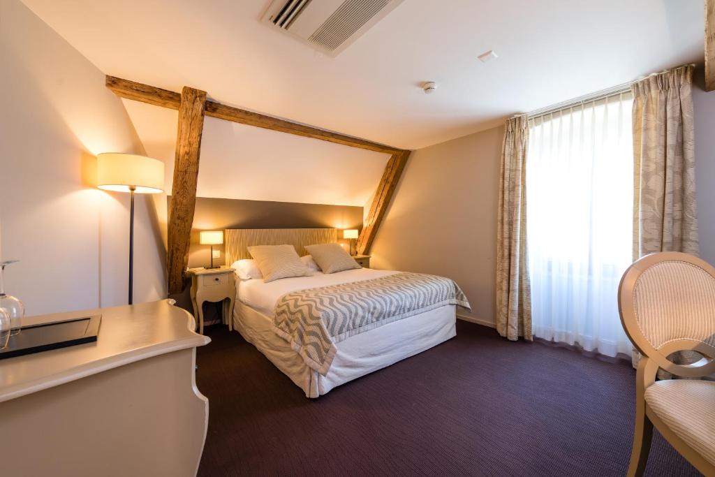 Postel nebo postele na pokoji v ubytování Hostellerie Le Petit Manoir