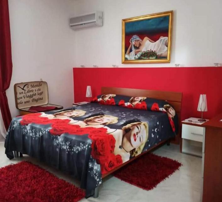 a large bed in a room with a red wall at B&B Omer in Sciacca