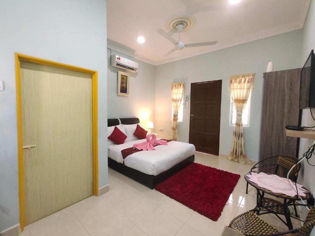 ein Schlafzimmer mit einem Bett mit einer rosa Schleife darauf in der Unterkunft Ku's Roomstay in Pantai Cenang