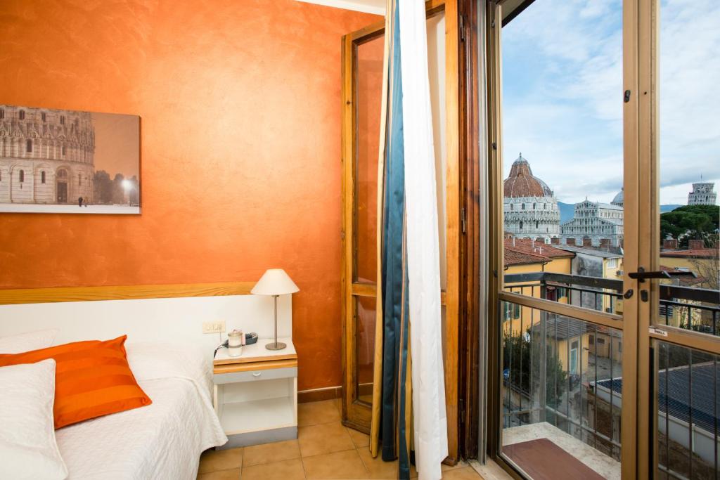 a bedroom with a bed and a large window at Hotel Roma in Pisa