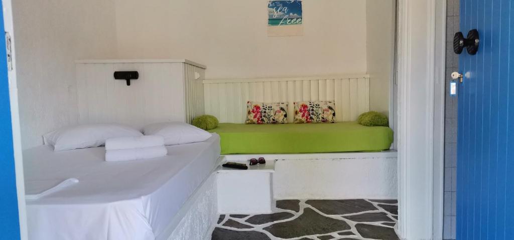 a bedroom with a bed and a green bench at Spasmata studios in Minia