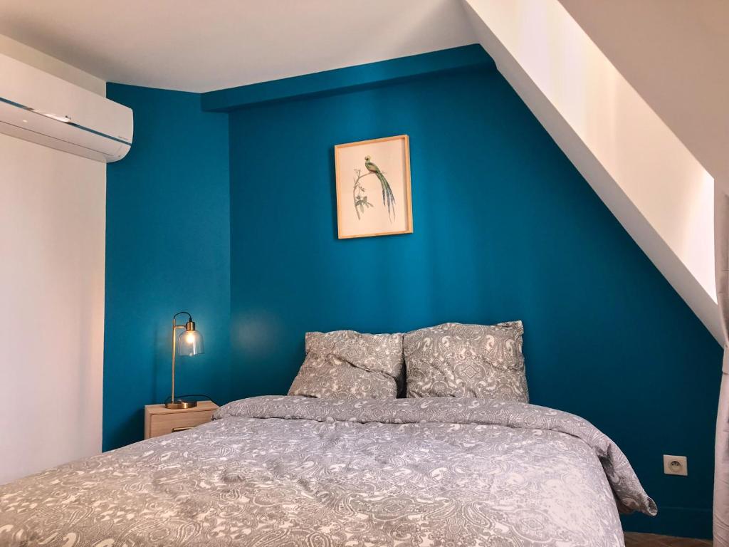 a bedroom with a blue wall with a bed at Logement dans le Vieux Tours in Tours