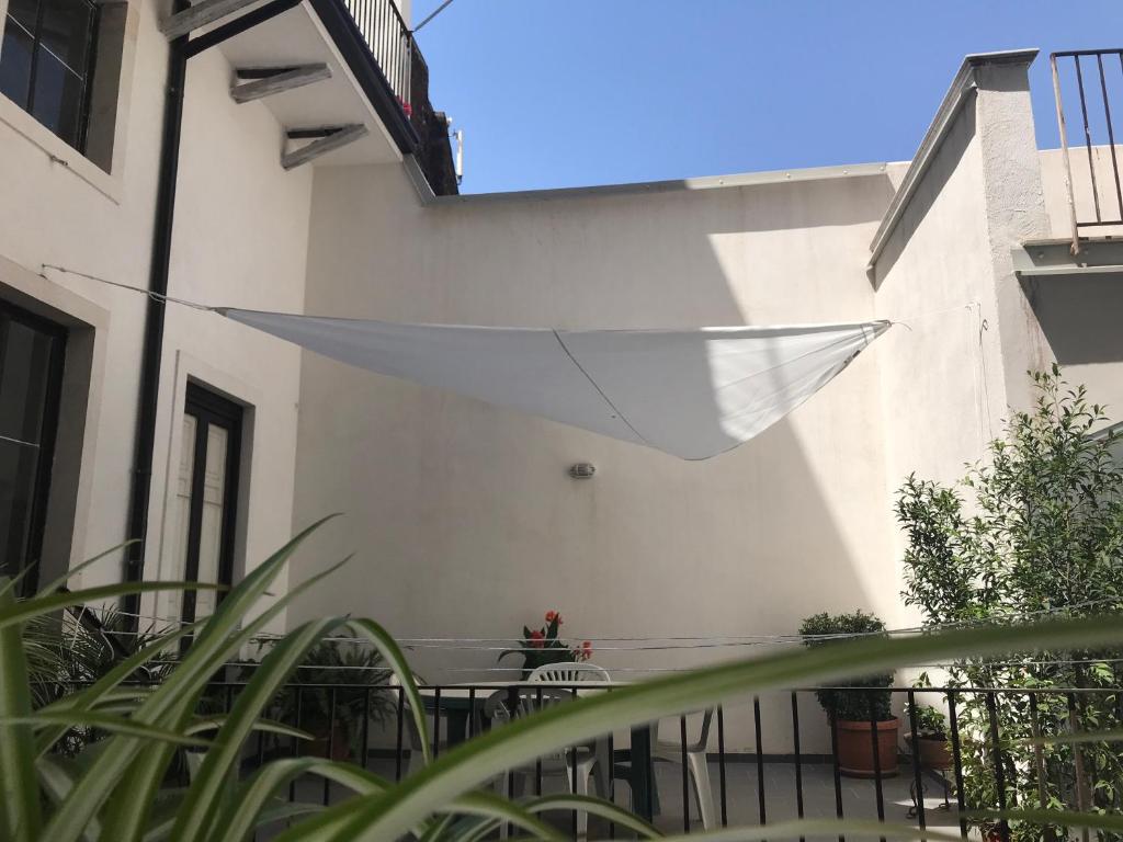 un parapluie blanc suspendu du côté d'un bâtiment dans l'établissement Chez Claudia - Relax in Catania city center, à Catane