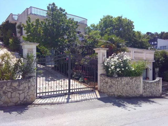 une porte en face d'une maison fleurie dans l'établissement Villa Caroline, à Trogir