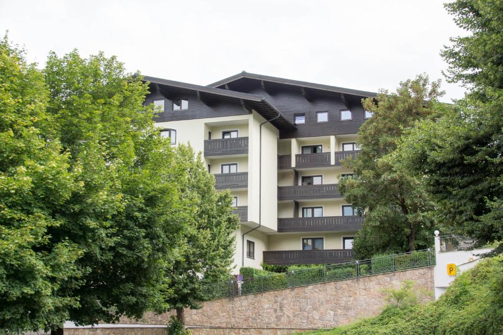 an apartment building with balconies and a wall at Apartment Grüner Baum Alpendorf in Sankt Johann im Pongau