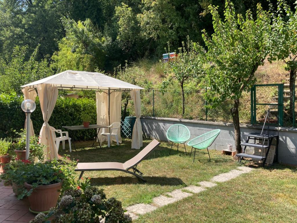 um jardim com uma tenda, cadeiras e uma mesa em Home Azzurra em Capolona