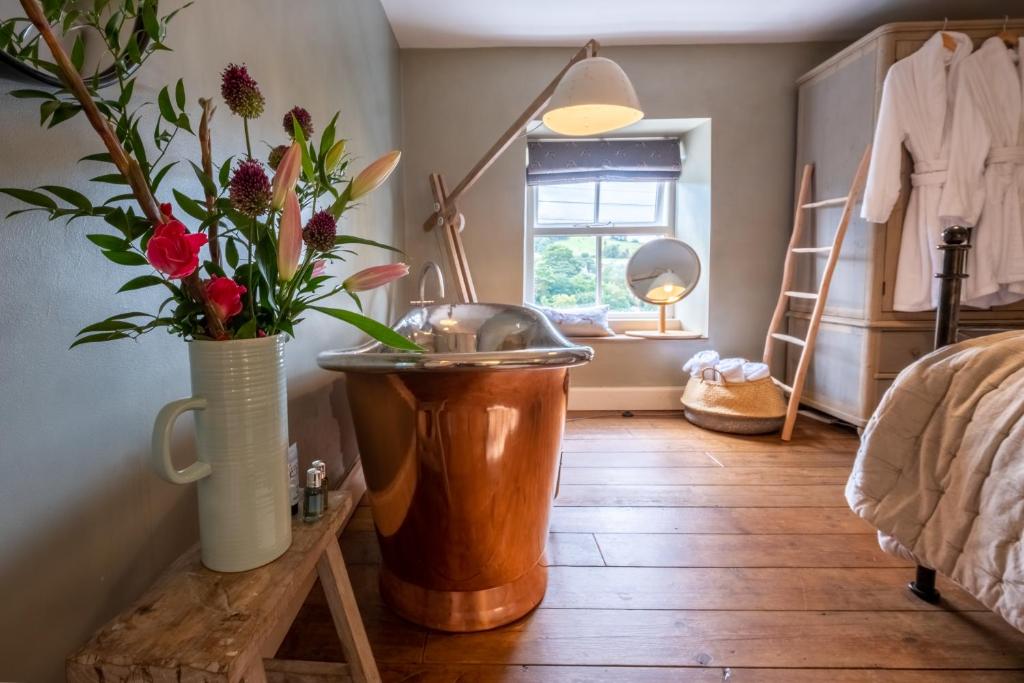 een badkamer met een wastafel en bloemen in een kamer bij Sett Cottage, Hayfield in Hayfield