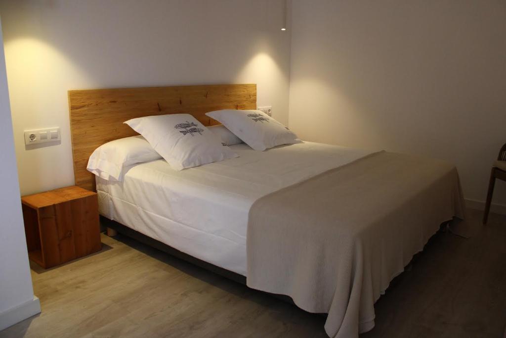 a hotel room with a white bed and white comforter at Horta d'en Rahola - Adults Only in Cadaqués