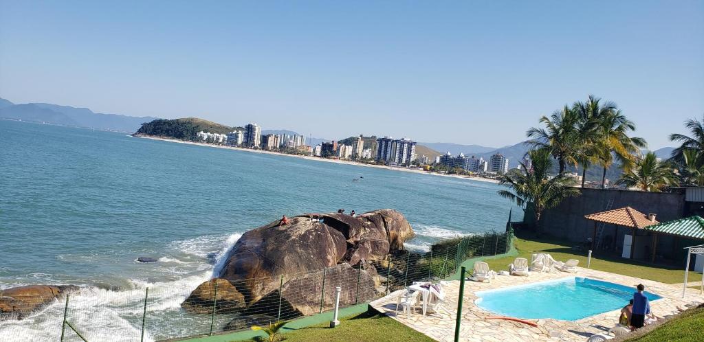 Изглед към басейн в Flat pé na areia Iate Club Martim de Sá или наблизо