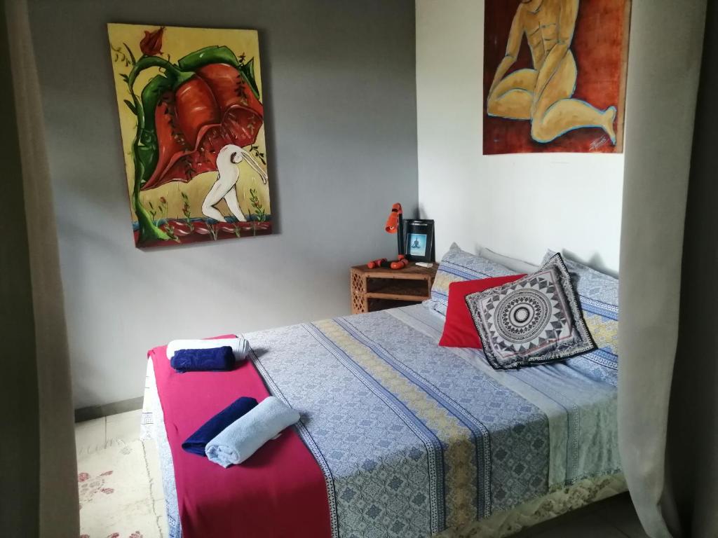 1 dormitorio con 1 cama y una pintura en la pared en Chalé "Oasis" en Praia do Forte