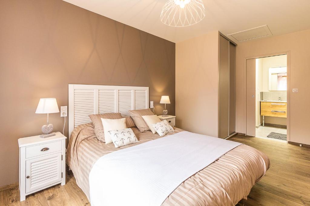 une chambre avec un grand lit et un lustre dans l'établissement Les prairies du Mont -La vallée Saint Pierre, à Sougéal