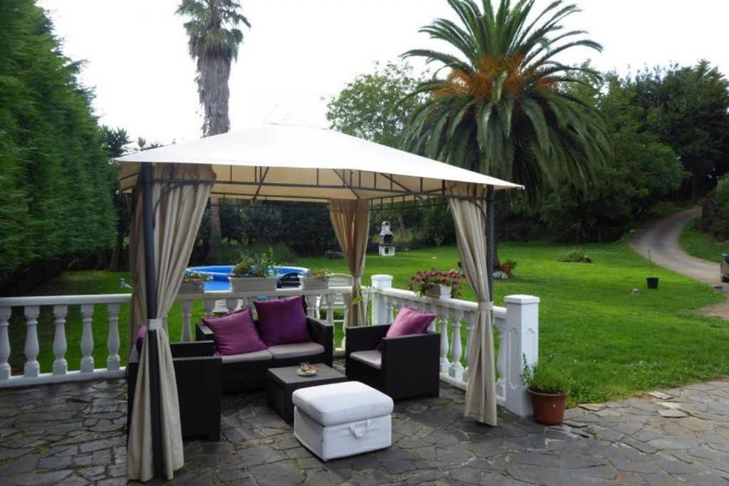 altana z krzesłami i parasolem w obiekcie La Rocosa w mieście Muriedas