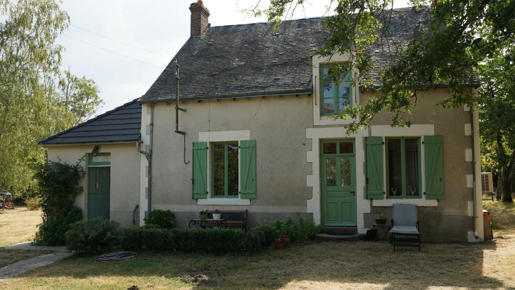 a white house with green shutters on it at Maison La Brenne in Sacierges-Saint-Martin