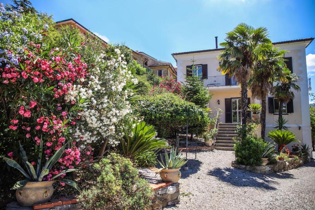 un giardino con fiori e piante di fronte a una casa di B&B La Residenza Torchiara a Torchiara