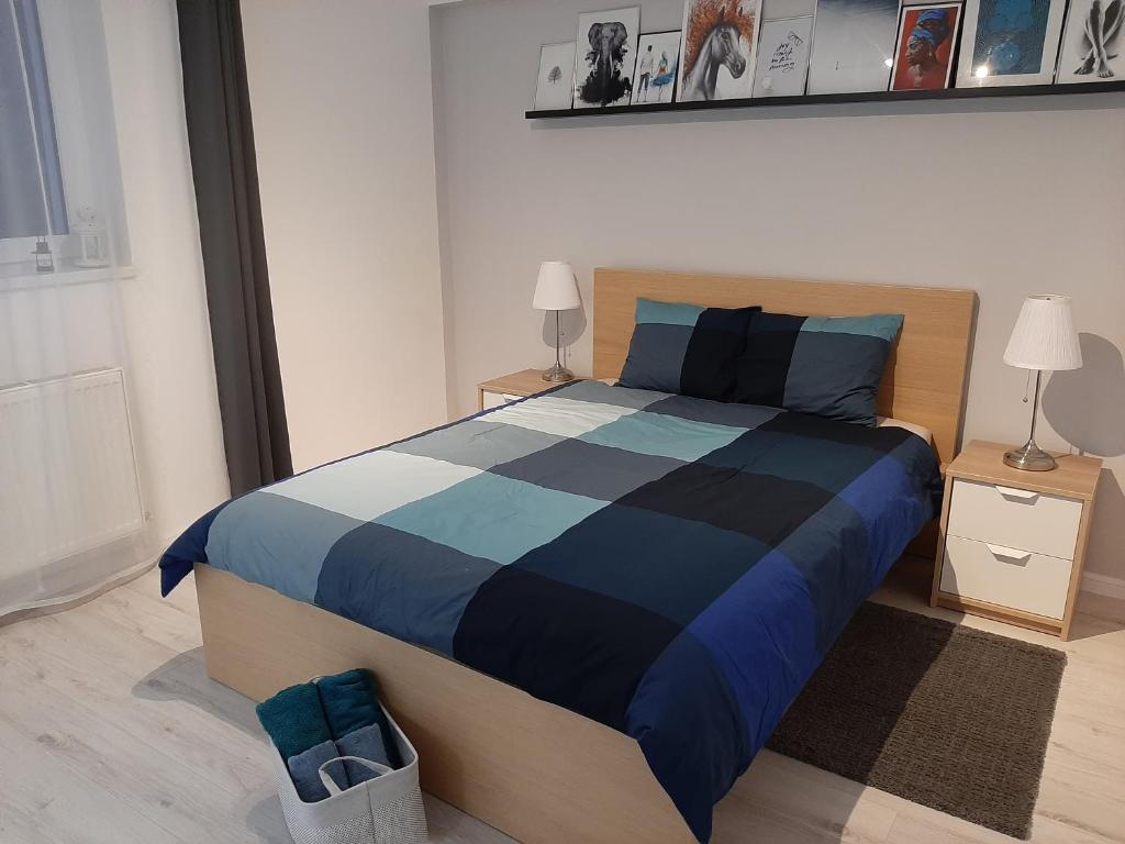 a bedroom with a bed with a blue and black comforter at Light HOUSE in Cluj-Napoca