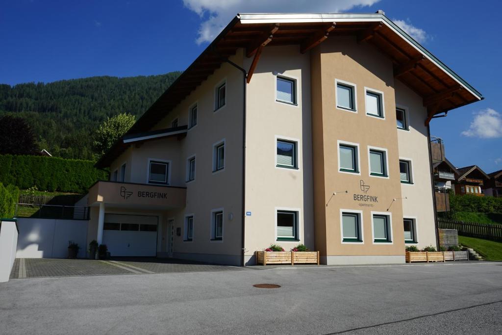 ein großes weißes Gebäude mit einem Dach in der Unterkunft Bergfink apartments in Flachau