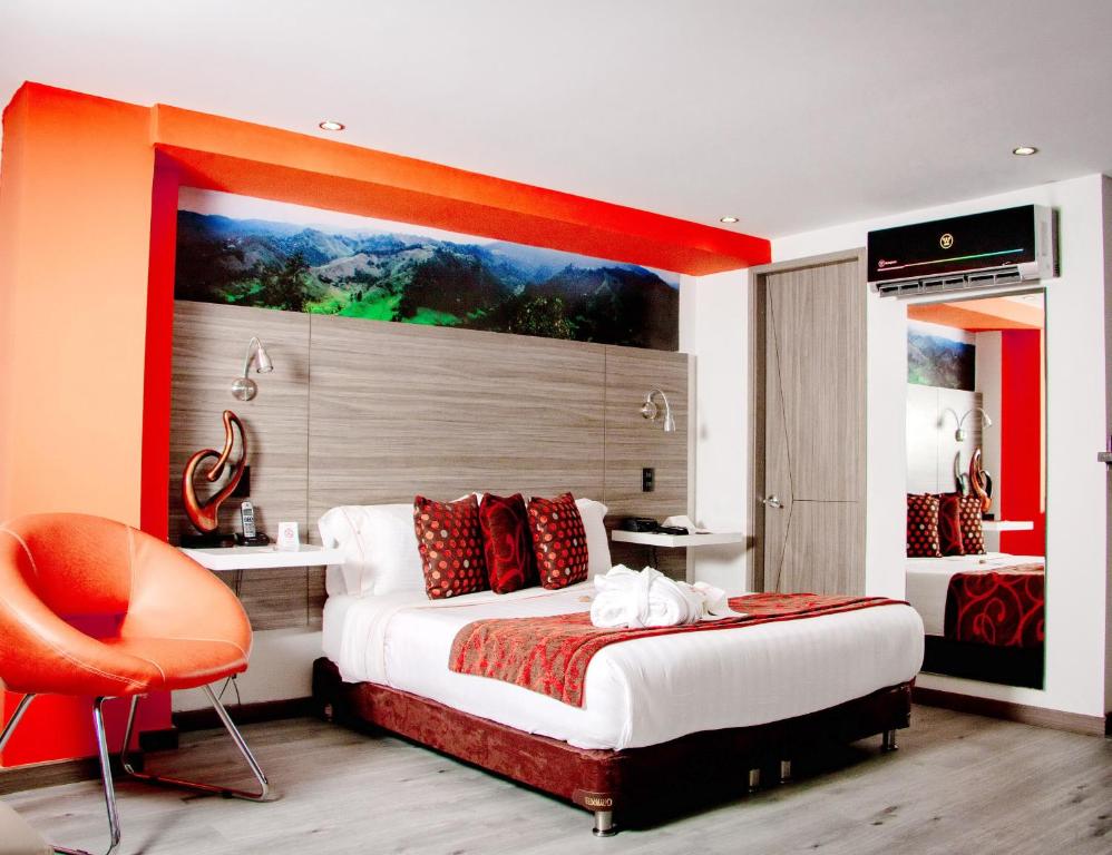 a bedroom with a large bed and a orange chair at Isa Victory Hotel Boutique in Armenia