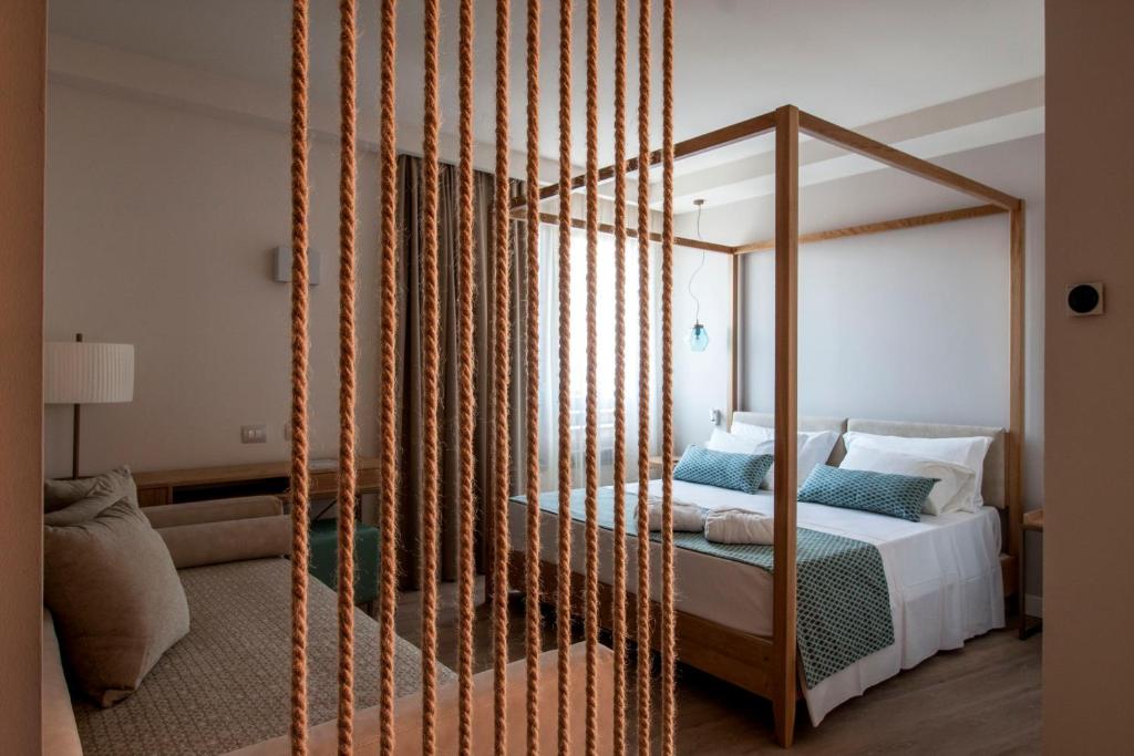 1 dormitorio con cama con dosel en una habitación en Aqua Boutique Hotel en Castiglione della Pescaia