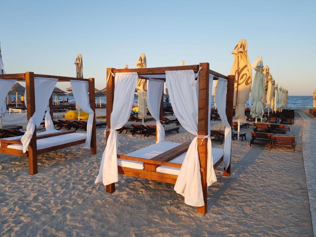 a group of beds on the beach at Eros Beach Resort in Mamaia Nord