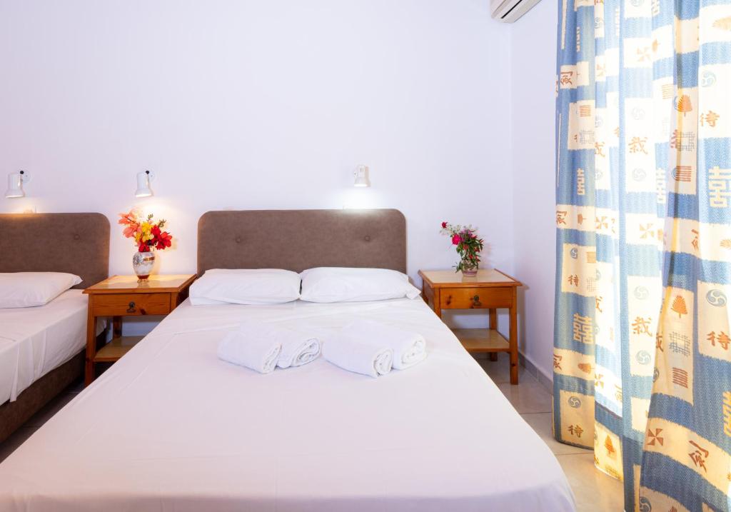 a bedroom with a bed with towels on it at Hotel Korakakis Beach in Finikounta