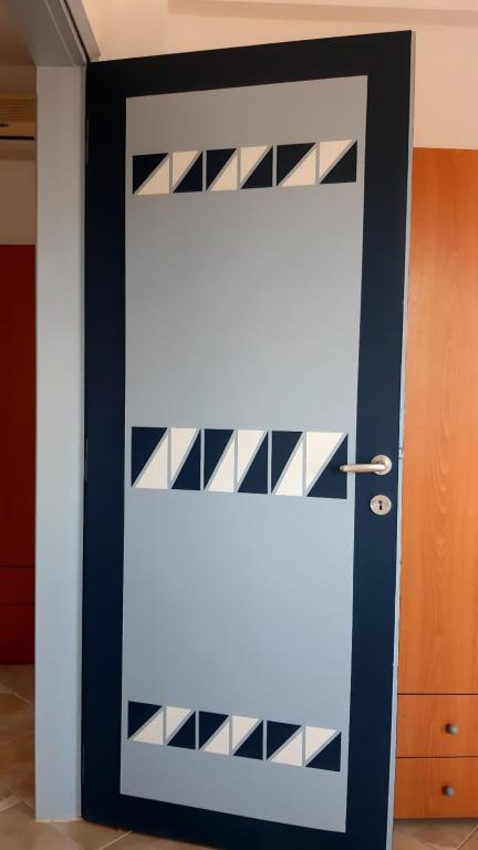 a white door with black and white panels at House Anna Houhlia in Vourvourou