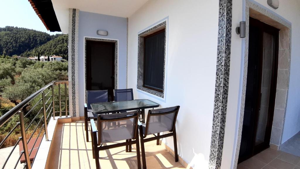 a table and chairs on the balcony of a house at House Anna Houhlia in Vourvourou