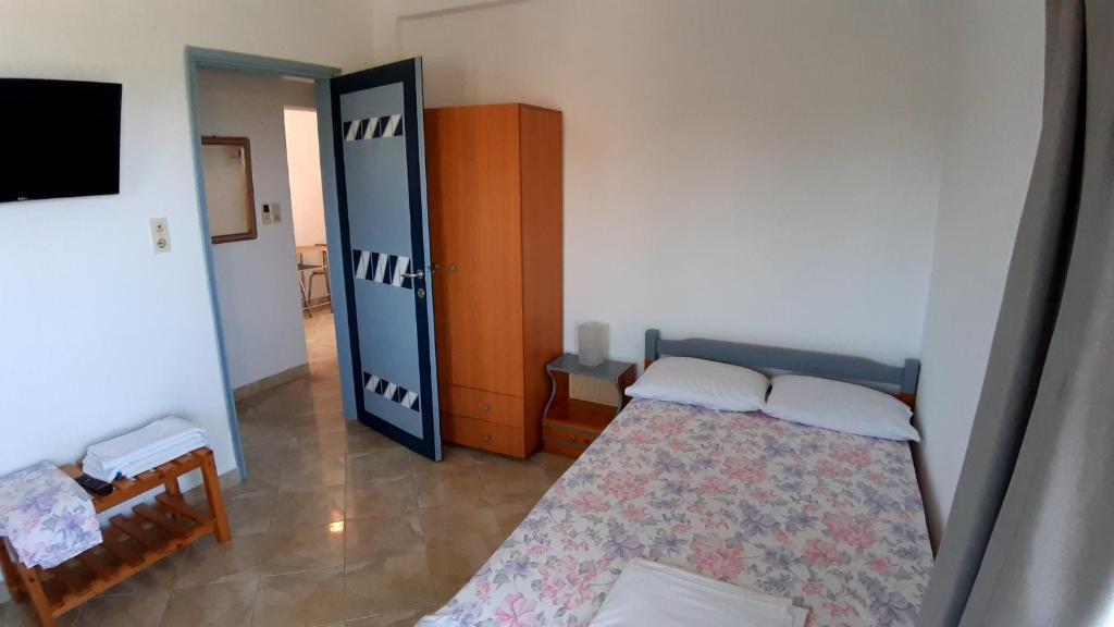 a small bedroom with a bed and a cabinet at House Anna Houhlia in Vourvourou