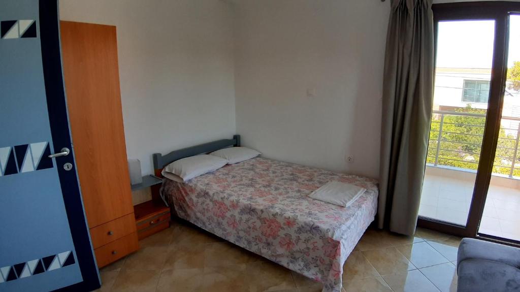 a small bedroom with a bed and a window at House Anna Houhlia in Vourvourou