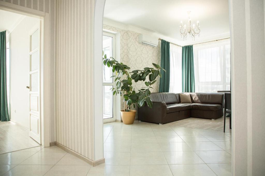キーウにあるDnipro view Slavutich apartmentのリビングルーム(ソファ、植物付)